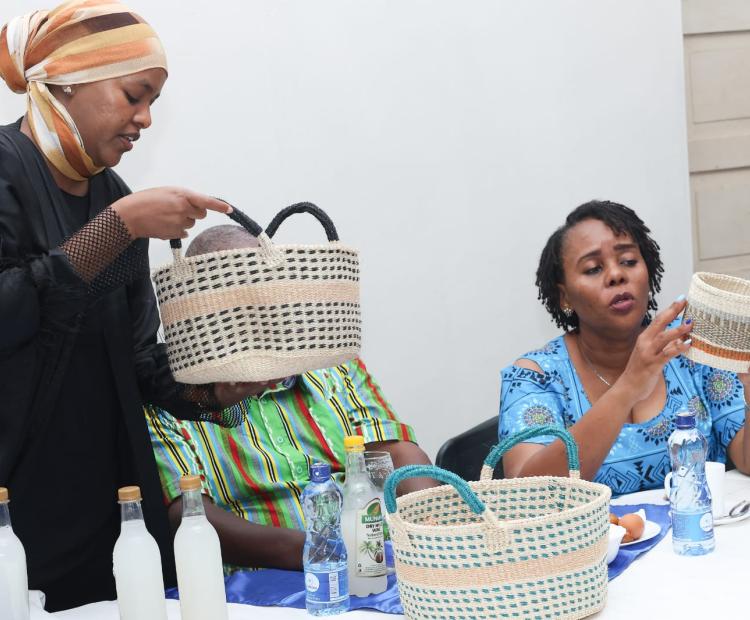 Photo Caption: Hibo Hussein (Left), Manager, Research, Innovation and IP Information, KIPI, showing HE  Flora Mbetsa Chibule (Seated Centre), Deputy Governor, Kilifi County, some of the coconut products the participants exhibited during the Training