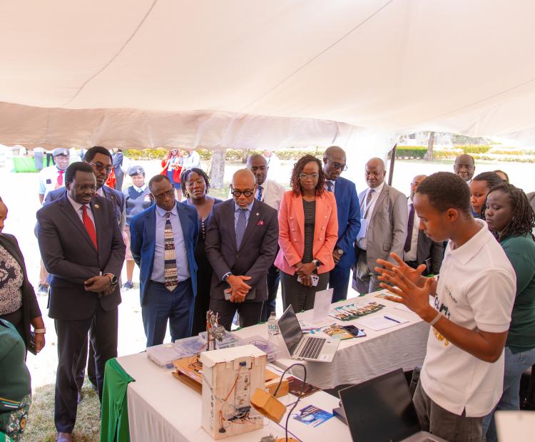 Photo: Prof. Henry Kiplangat (3rd left with a red tie), Kabarak University Vice Chancellor, Stephen Ngeno (4th Left), Deputy Managing Director, Technical Services, and Ralph Opara (5th Left), Access Bank Kenya Country Managing Director, listen to one of the innovators when they toured the exhibition stands during the Innovation Week in Kabarak, Nakuru County.